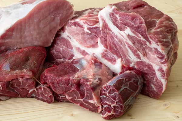 Different types of raw pork meat and beef. Raw meat on wooden ta — Stock Photo, Image