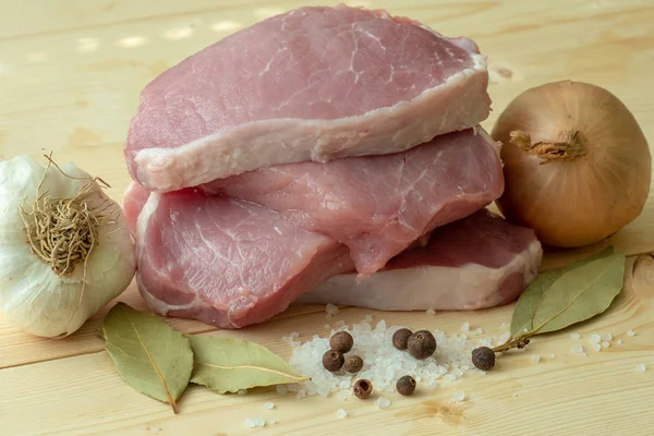 Carne di maiale fresca con ingredienti per la cottura su tavola di legno — Foto Stock