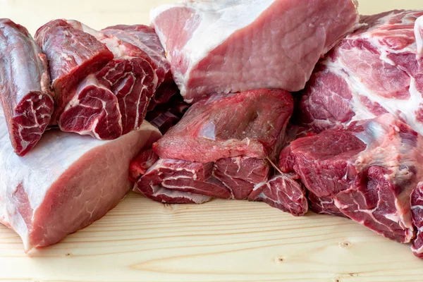 Different types of raw pork meat and beef. Raw meat on wooden ta — Stock Photo, Image