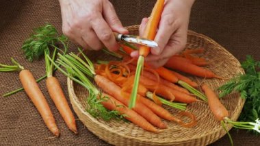 Kök sebze. Havuç peeling Closeup kadının elleri.