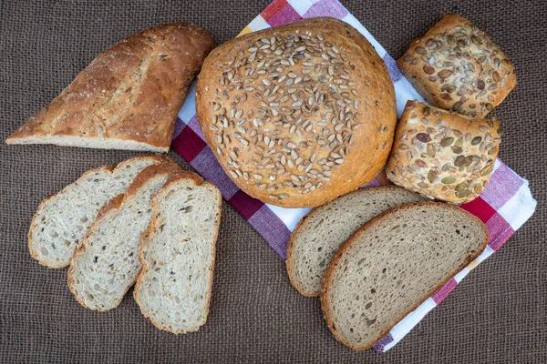 Friss kenyér az asztalon, felülnézetből. Sült sötét kenyér és szeletelt brea — Stock Fotó
