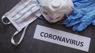 Korunaklı tıbbi maskeli, eldivenli ve koronavirüs salgını için FFP2 maskeli siyah arkaplan Coronavirus metni..