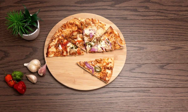 Tahta arka planda biber ve sarımsaklı pizza.