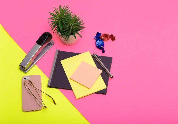 Renkli arka planda çeşitli ofis malzemeleri.