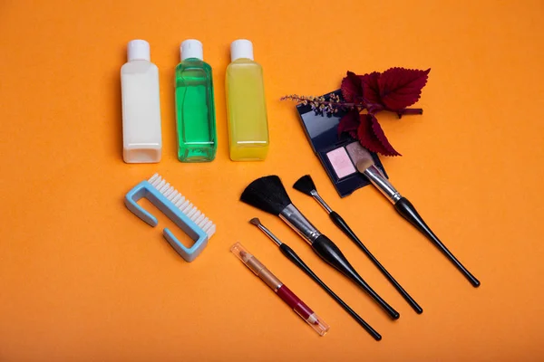 Makyaj fırçaları ve aksesuarları turuncu üzerine konur.