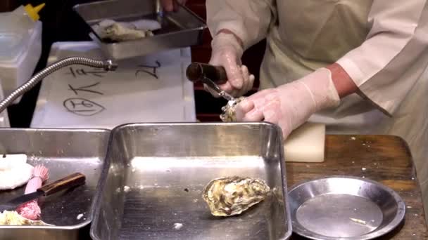 Frische Austern öffnen sich auf dem Nishiki-Markt. Hände, die eine Auster und ein Messer zum Shucken halten. — Stockvideo