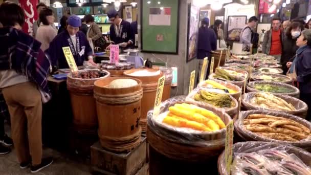 Clientes em uma loja com vários vegetais marinados no mercado Nishiki, Kyoto, Japão — Vídeo de Stock