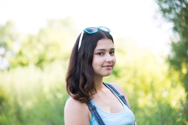 Chica con gafas de sol en la cabeza posando en la naturaleza — Foto de Stock