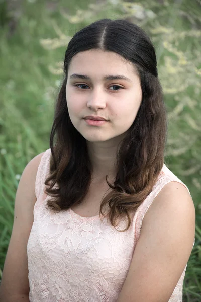 A lány Sötét haja a zöld fű háttér — Stock Fotó