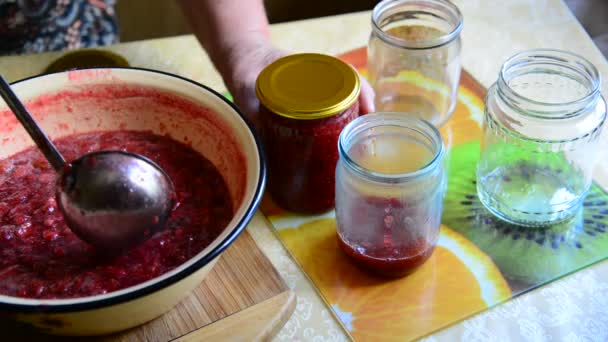 Woman puts handmade Strawberry jam in jar — Stock Video