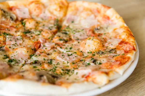 Пицца с грибами и ветчиной на тарелке — стоковое фото