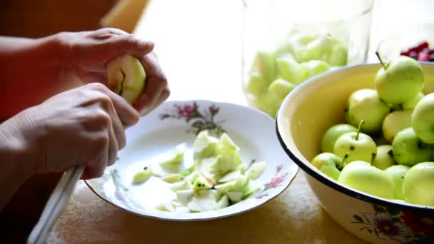 Жінка ріже яблука для приготування консервованого компоту — стокове відео