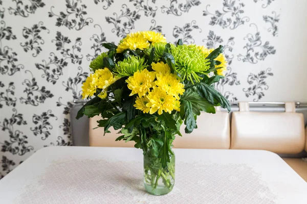 Букет желтых и зеленых хризантем, стоящих на кухонном столе — стоковое фото