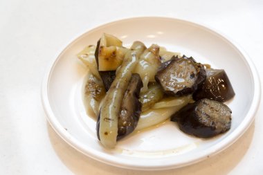 Közlenmiş biber ve patlıcan tek kullanımlık plaka üzerinde