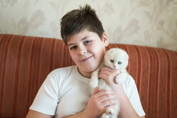 Boy teenager holding kitten in her arms — Stock Photo, Image