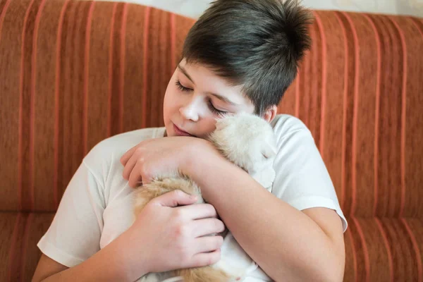 Niño adolescente sosteniendo gatito en sus brazos — Foto de Stock