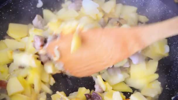 Картопля з м'ясом смажать на сковороді — стокове відео