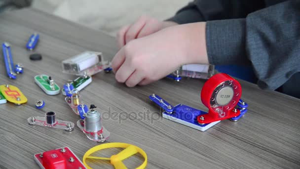 Boy assemble le circuit électrique du constructeur — Video