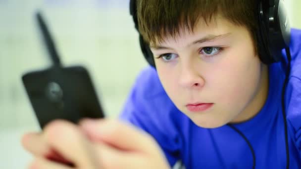 Teenager benutzen Handy mit Kopfhörer — Stockvideo