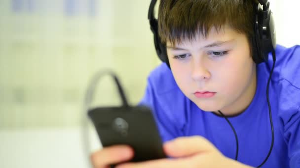 Adolescente usando telefone celular com fones de ouvido — Vídeo de Stock