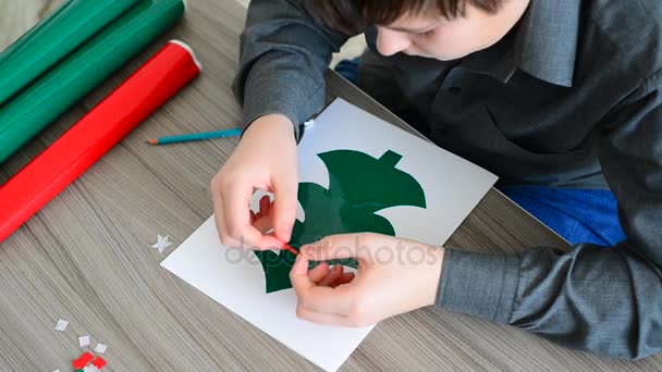 十代の男の子のクリスマスのカードを作る — ストック動画