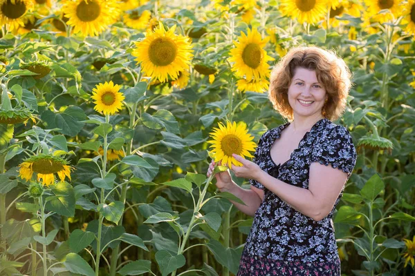 Femme aux cheveux bouclés dans le champ de tournesols — Photo