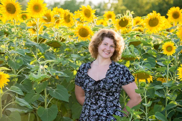 Donna dai capelli ricci nel campo dei girasoli — Foto Stock