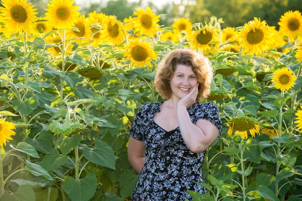 Donna dai capelli ricci nel campo dei girasoli — Foto Stock