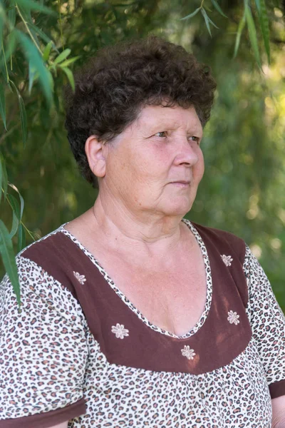 Mature woman with curly hair near weeping willow — Stock Photo, Image