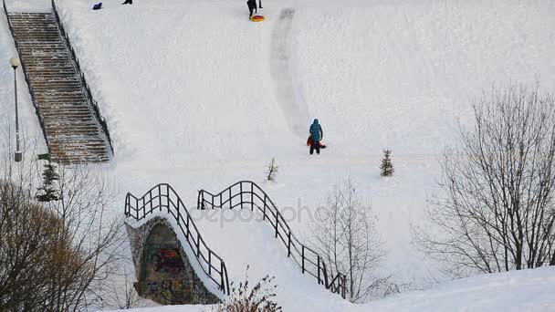 Moskva, Ryssland - December 19.2016. Barn glida ner på ice slide och mamma titta på — Stockvideo