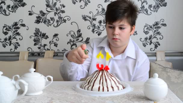 Niño enciende velas en el pastel con un encendedor — Vídeos de Stock