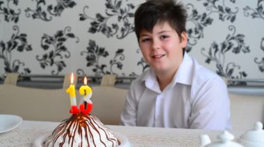 13 numaraları ile kek üzerine mumlar çocuk söndürür