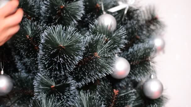 Femme décorer arbre de Noël artificiel avec des boules et des arcs — Video