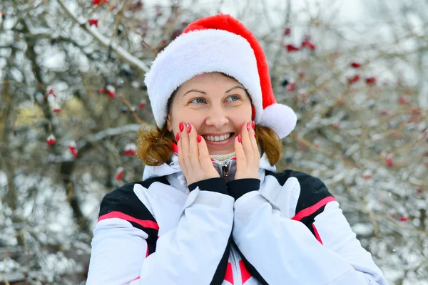 Frau mit Mütze Weihnachtsmann auf dem Hintergrund von Viburnum — Stockfoto