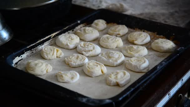 Abuela pone rollos de masa cruda en bandeja para hornear — Vídeos de Stock