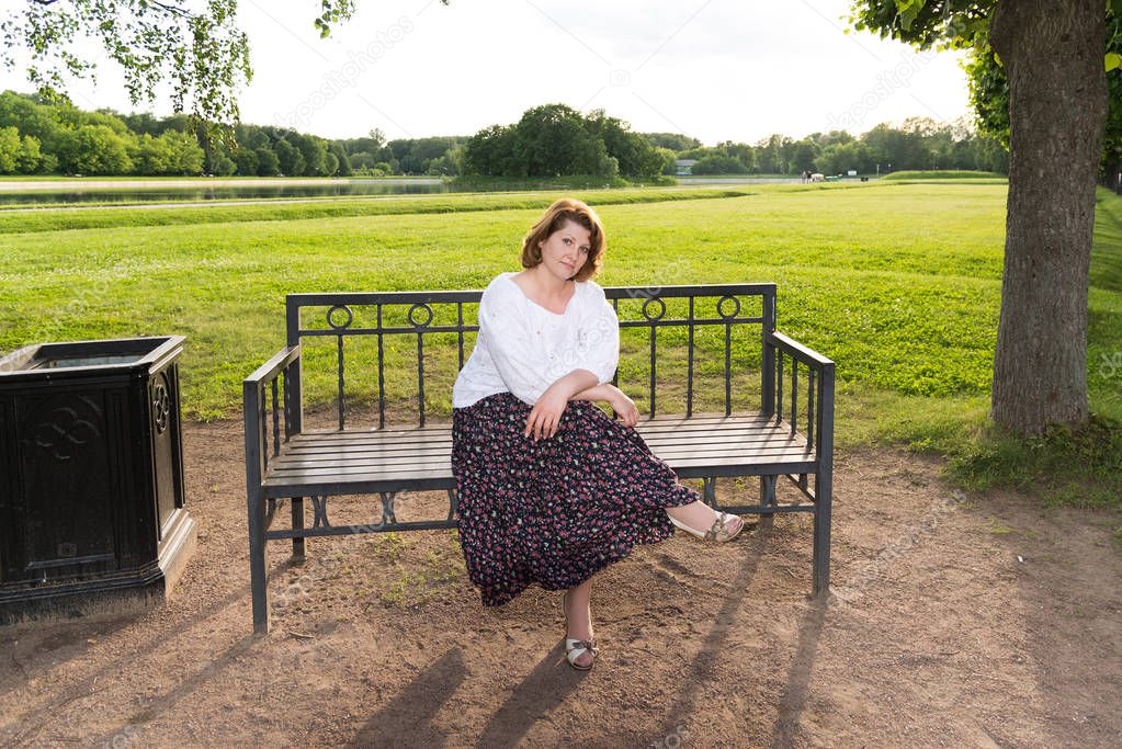 woman sitting on bench in summer park