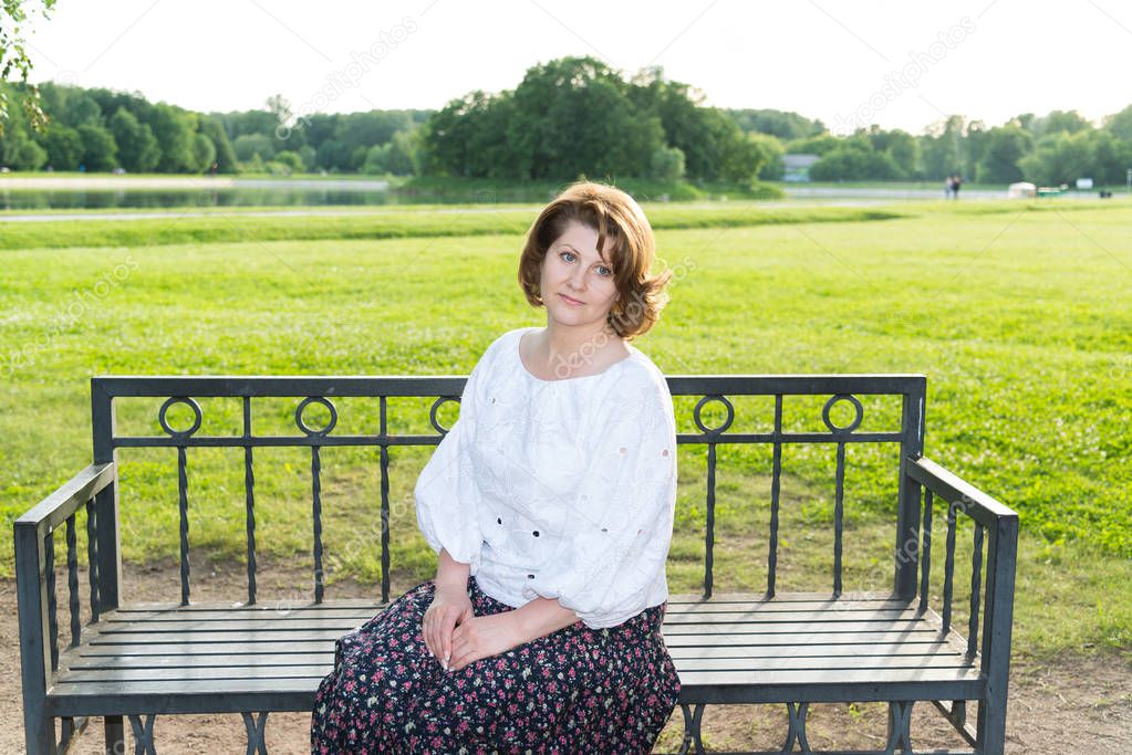 woman sitting on bench in summer park