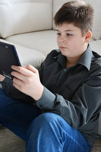 Jongen tiener met een tablet in kamer — Stockfoto