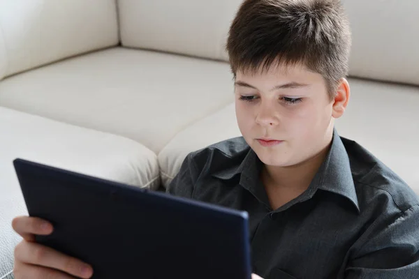 Boy teenager with a tablet in room — Stock Photo, Image