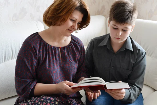 Mutter und Sohn lesen im Zimmer ein Buch — Stockfoto