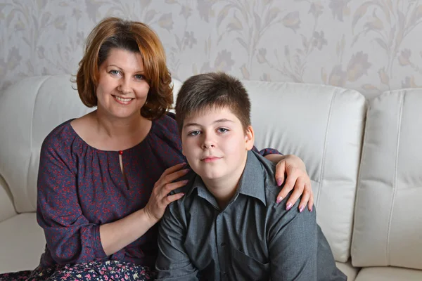 Moeder en zoon zittend op een bank in de kamer — Stockfoto