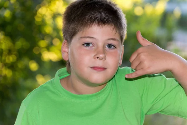 Мальчик показывает жест говорящий по телефону — стоковое фото