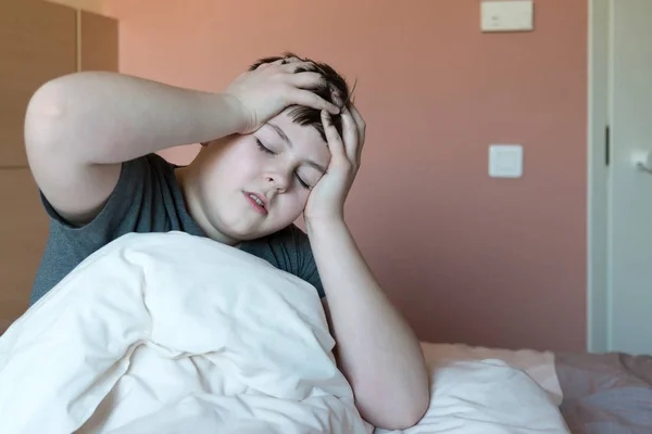 Хлопчик з головним болем сидить у ліжку — стокове фото