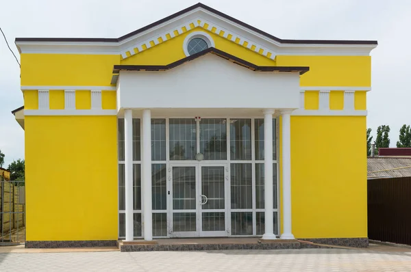 Edificio administrativo amarillo con puertas de cristal — Foto de Stock