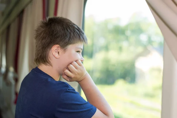 De jongen kijkt uit het raam op trein — Stockfoto