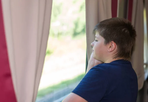 De jongen kijkt uit het raam op trein — Stockfoto