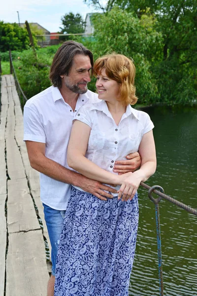 Happy couple on bridge across the river — Stock Photo, Image