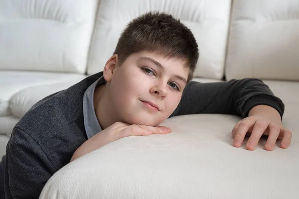 Niño de 13 años sentado cerca del sofá en la habitación — Foto de Stock