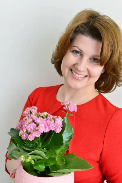 Frau hält Kalanchoe in einem Topf — Stockfoto