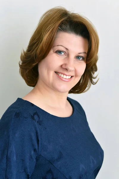 Portrait of woman in blue on light background — Stock Photo, Image